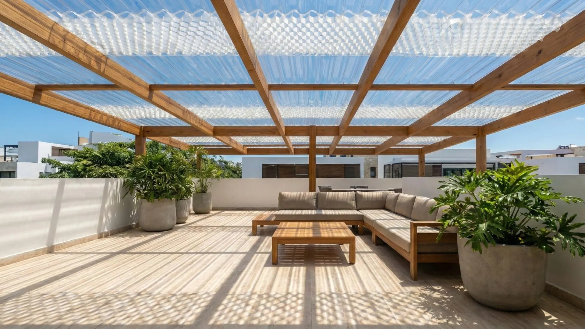 Perspectiva cenital de terraza moderna bajo sol intenso. El techo sol y sombra proyecta un patrón geométrico de sombras nítidas sobre el suelo de travertino, demostrando la eficacia del filtrado de luz sin sacrificar la luminosidad natural. Integración orgánica con el cielo azul y vegetación perimetral.