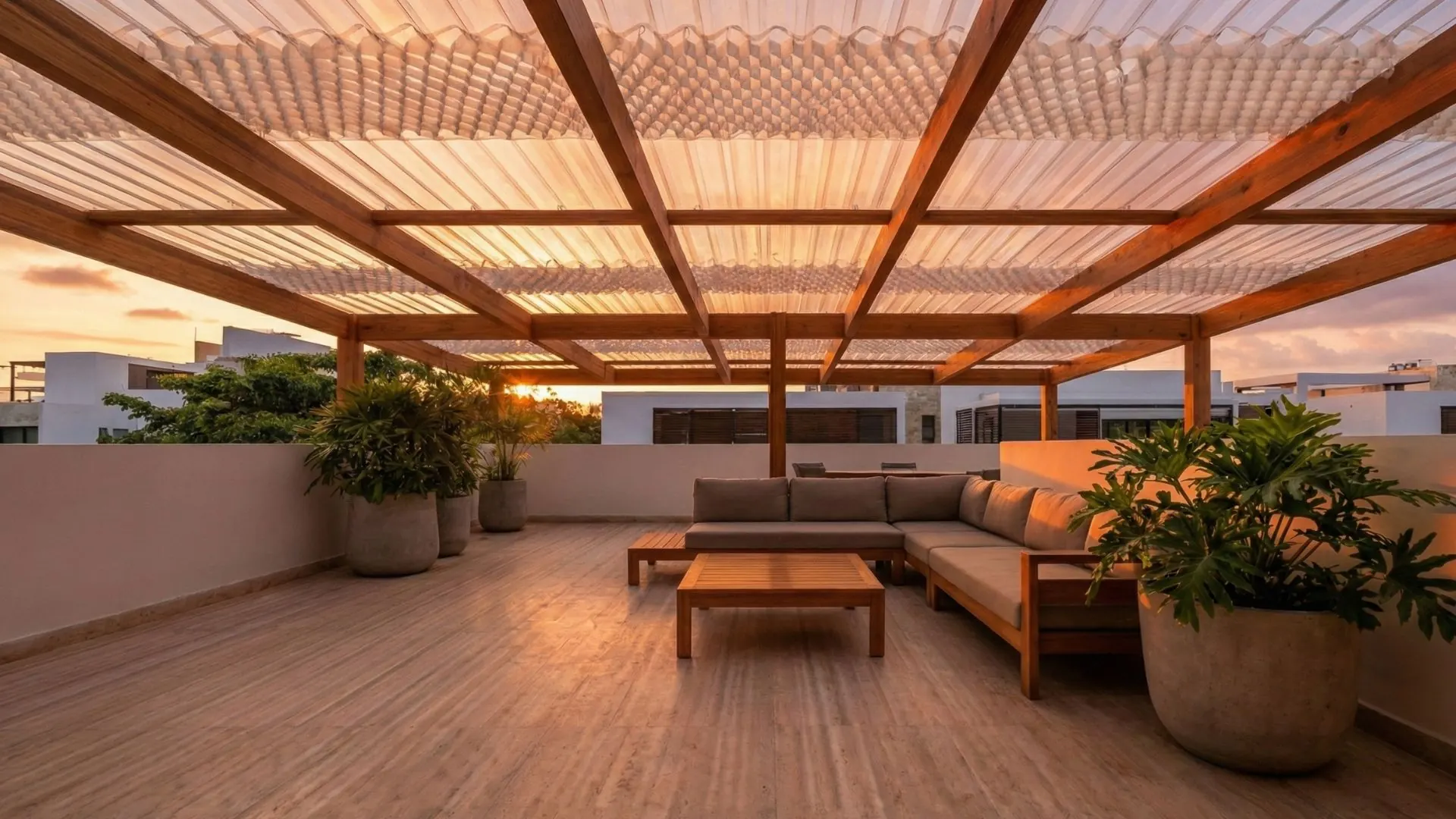 Atmósfera de hora dorada capturada en terraza penthouse. La luz rasante del atardecer incendia los tonos rojizos de la madera Huayruro, creando un contraste dramático con los tonos fríos del horizonte urbano. El policarbonato difumina el sol poniente convirtiéndolo en un resplandor ámbar envolvente.