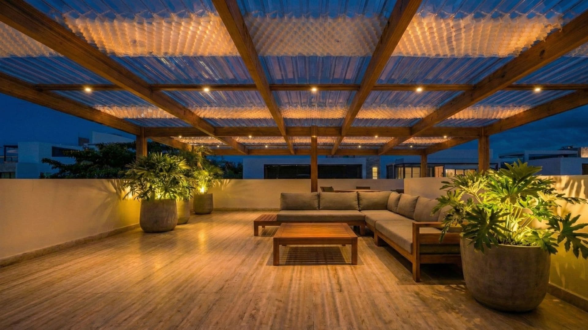 Composición nocturna de alta gama ('Blue Hour'). La estructura se transforma en una escultura lumínica mediante iluminación LED integrada en las vigas. El espacio irradia calidez y sofisticación frente a la oscuridad exterior, destacando el diseño de iluminación escénica y el mobiliario de autor.